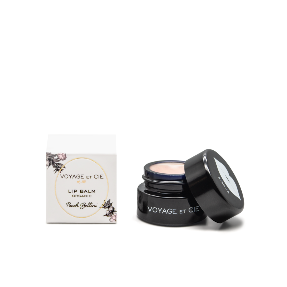 Organic lip balm jar, open lid showing pale beige balm; Peach Bellini flavor