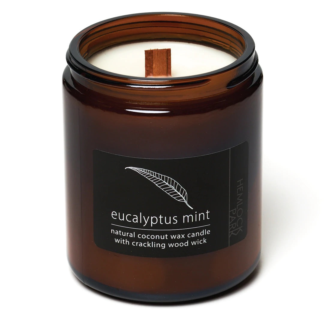 Coconut wax candle in amber jar with wood wick, eucalyptus mint scent label