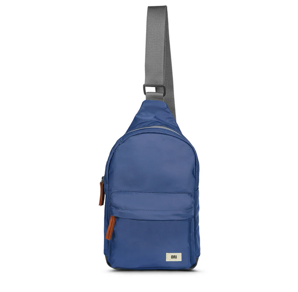Burnt blue recycled nylon sling bag with front zip pocket and gray adjustable strap