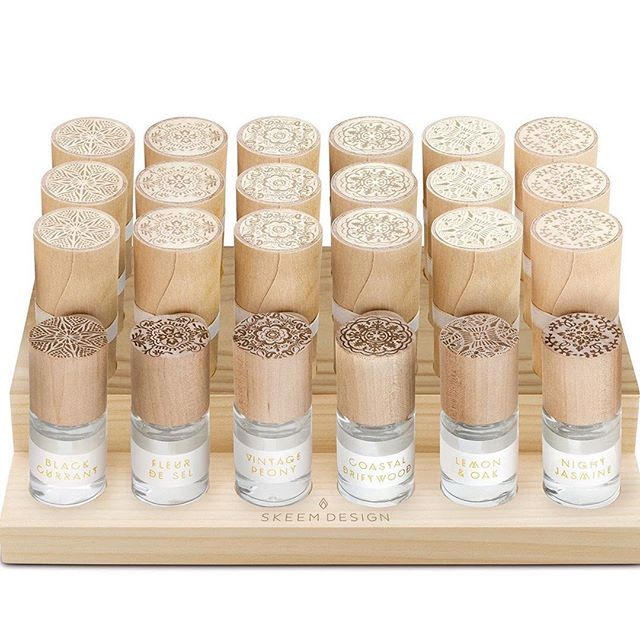 Rollerball perfume set of six bottles with carved wooden caps on a display tray