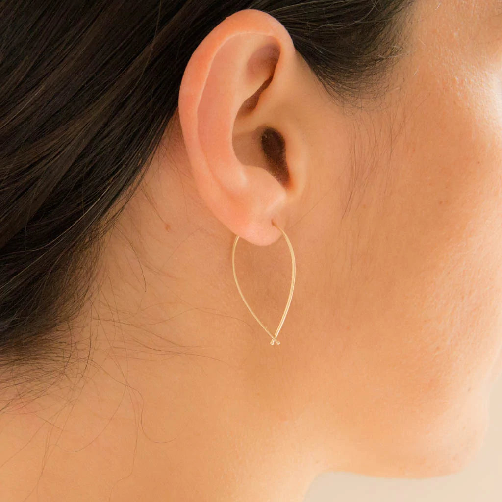 14k gold hoop earrings with teardrop ribbon loop, worn close-up