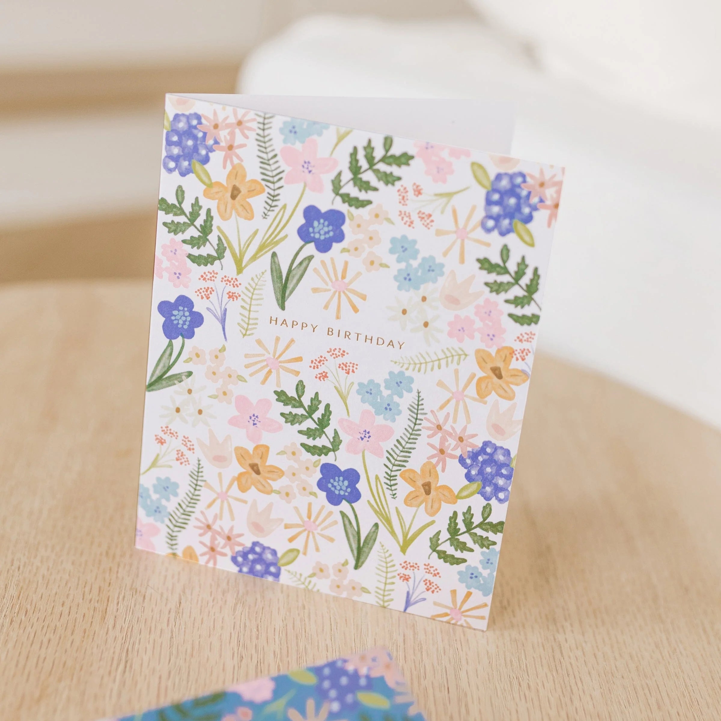 Pastel floral birthday greeting card, “Happy Birthday” centered on front