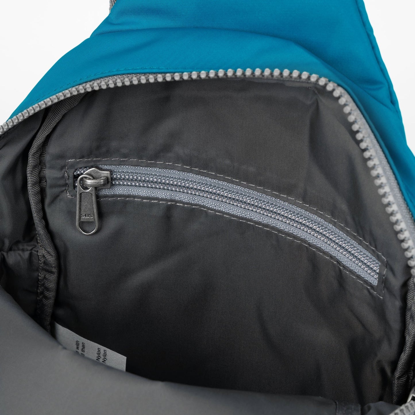 Recycled nylon sling bag interior with zippered pocket and silver zipper track