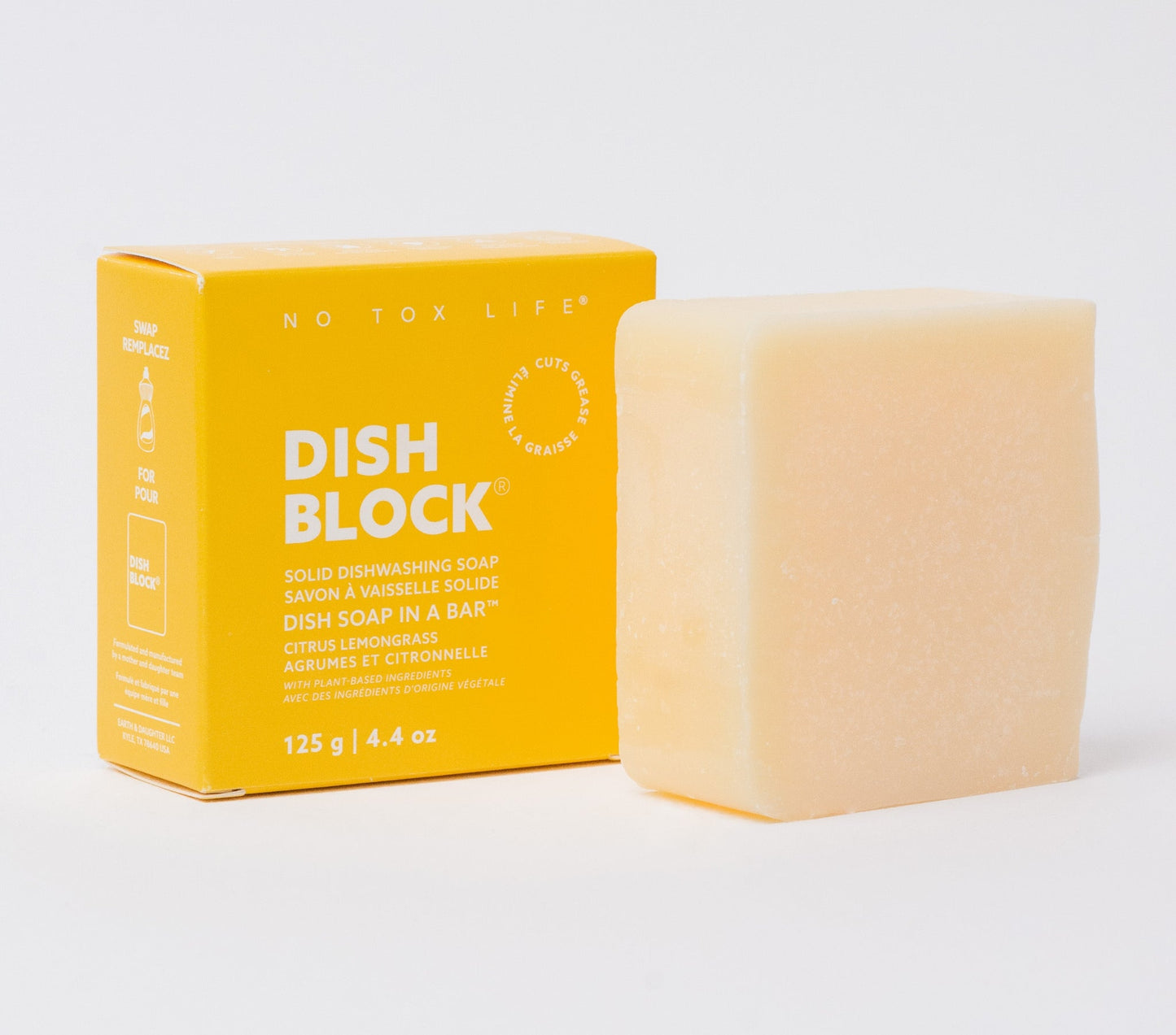 Solid dish soap block, pale yellow cube; next to yellow packaging.