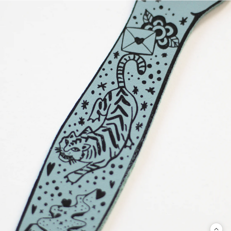 Heritage blue tattooed arm bookmark detail with envelope, flowers, and star motifs
