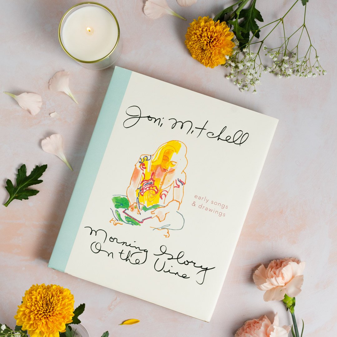 Song lyrics book with illustrated cover, pastel blue border and flower artwork