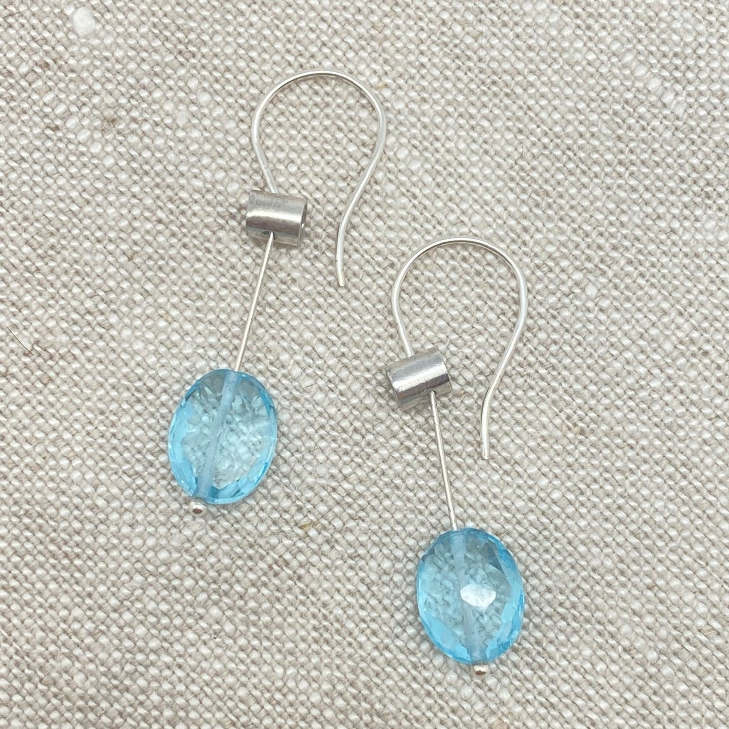 Silver-tone pivot drop earrings with oval blue topaz gemstones
