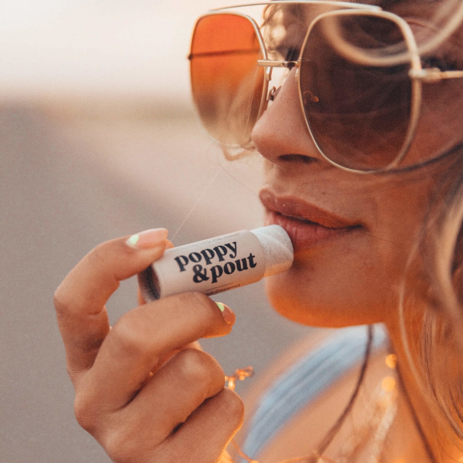 Lip balm tube held near lips, showing 'doppy & pout' label