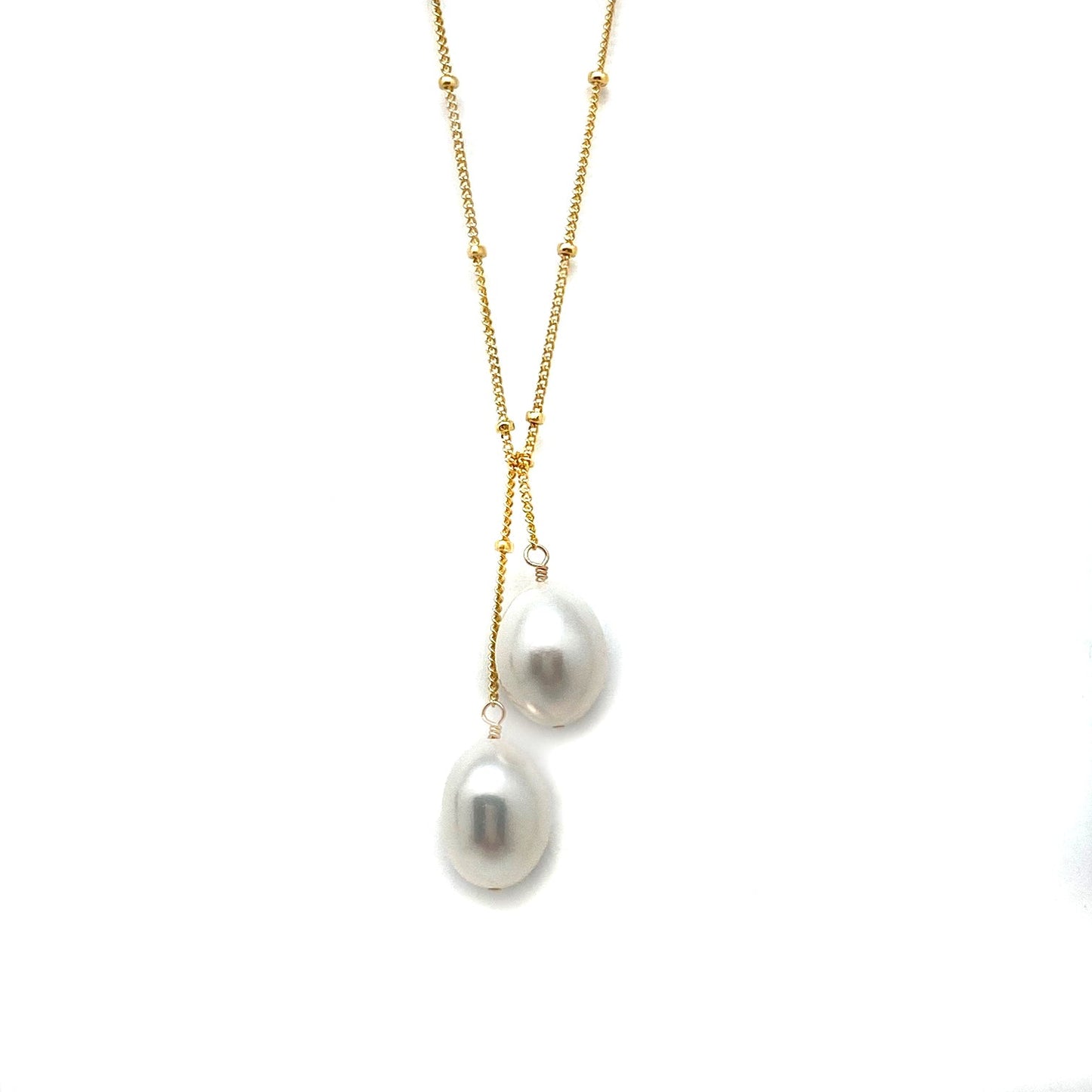 Gold lariat necklace with two white baroque pearls in a dangling drop