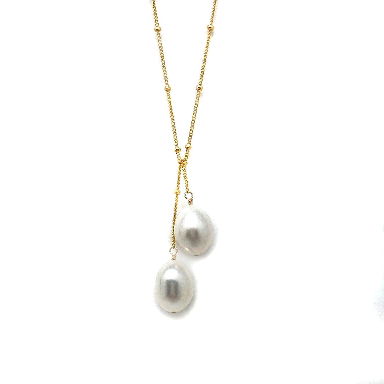 Gold lariat necklace with two white baroque pearls in a dangling drop
