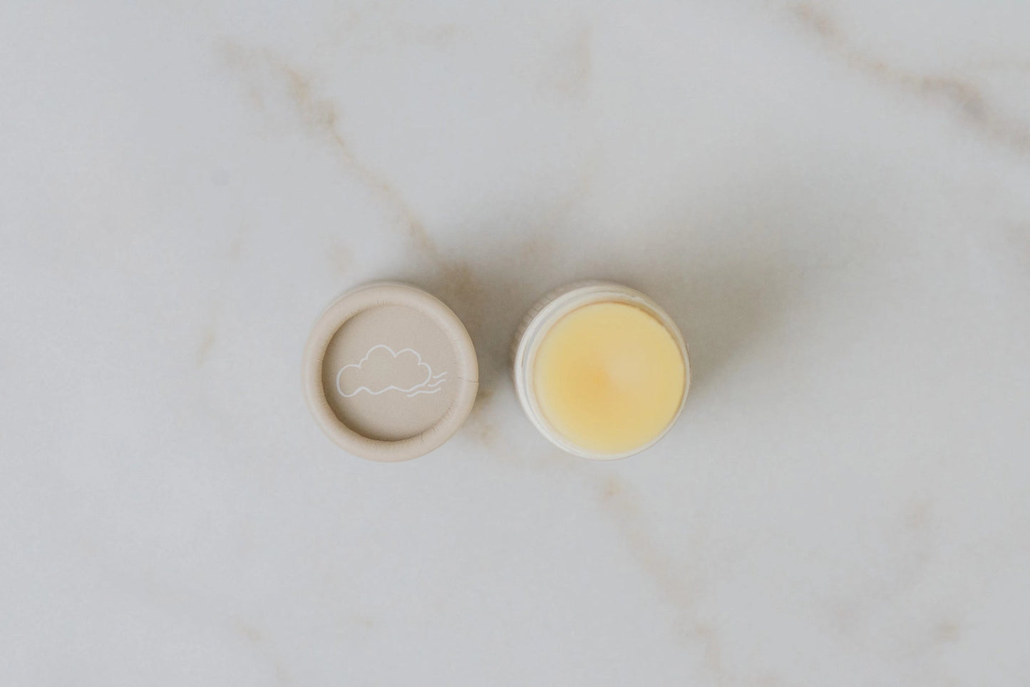 Lip butter tin and open balm pot showing pale yellow balm