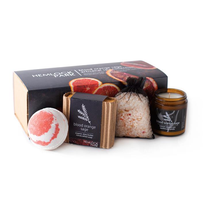 Spa gift set with blood orange sage candle jar, red bath bomb, bath soak pouch, and soap bar