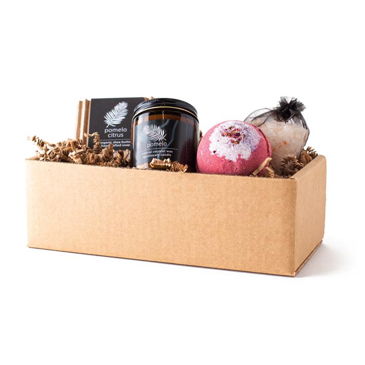 Spa gift set in kraft box with pomelo candle jar, bath bombs, and dried herbs