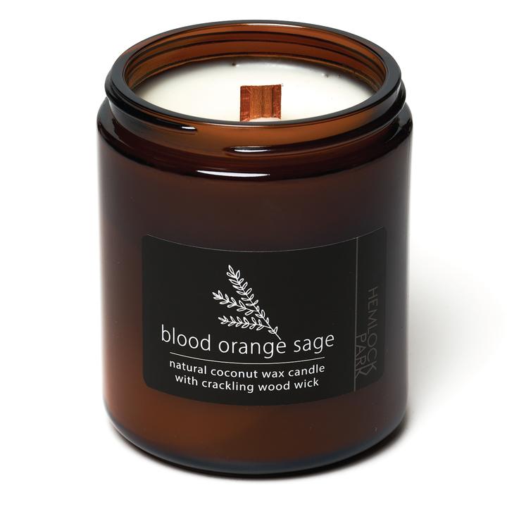 Coconut wax candle in amber jar with wood wick, blood orange sage scent label