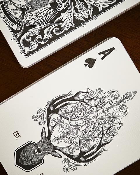 White playing card with ornate antler illustration and decorative tag label