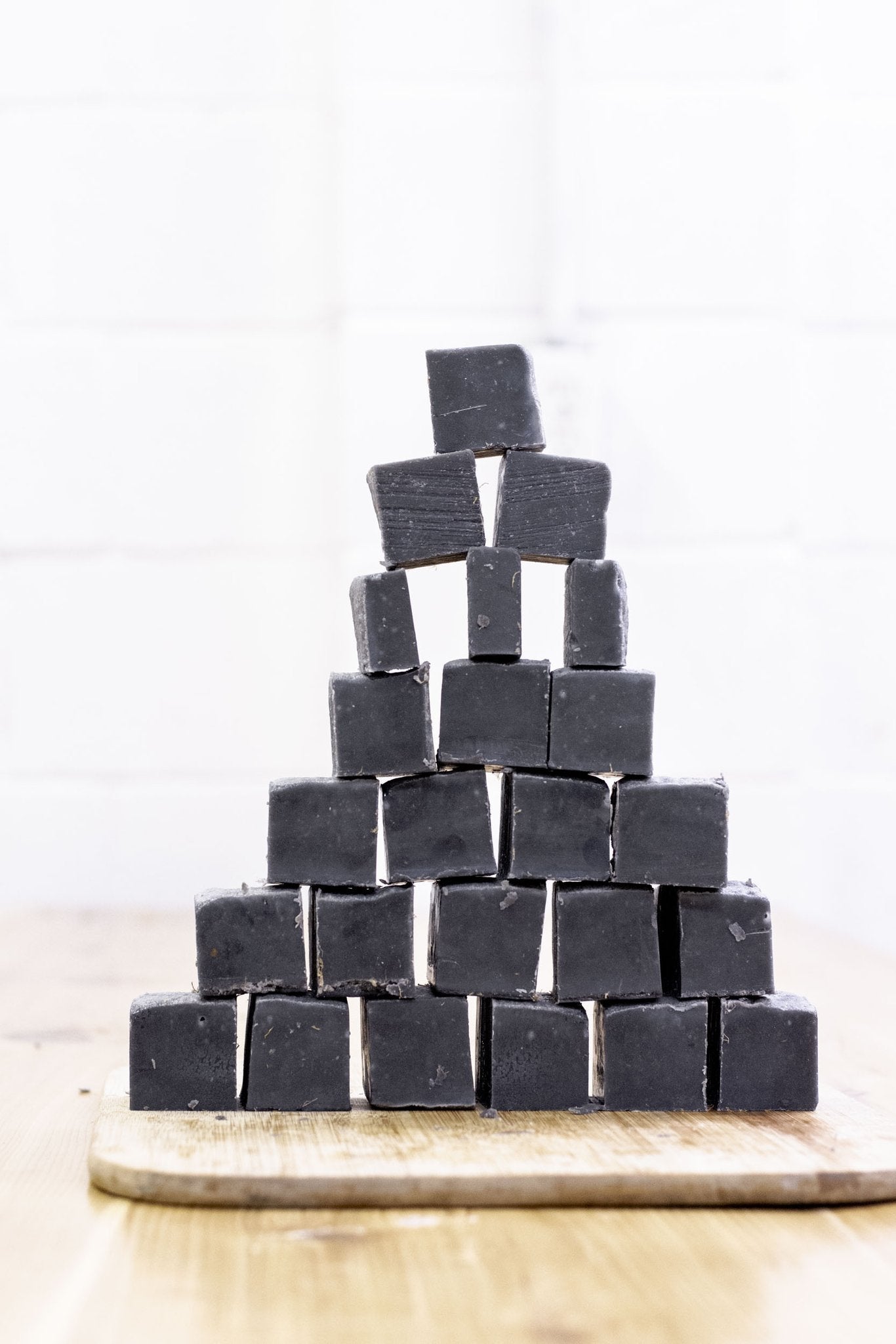 Stack of mini underarm detox solid cleansing bars, charcoal clay, dark gray-black