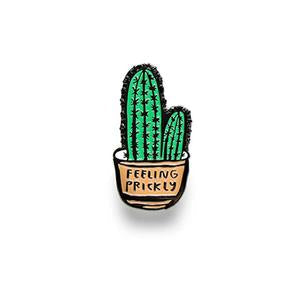 Green cactus enamel pin with two prongs and small label detail