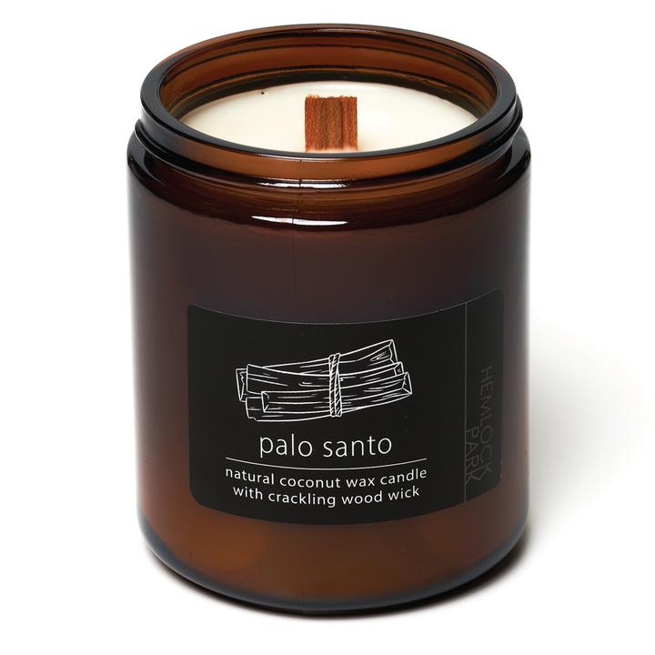 Coconut wax candle in amber jar with wood wick, palo santo scent label