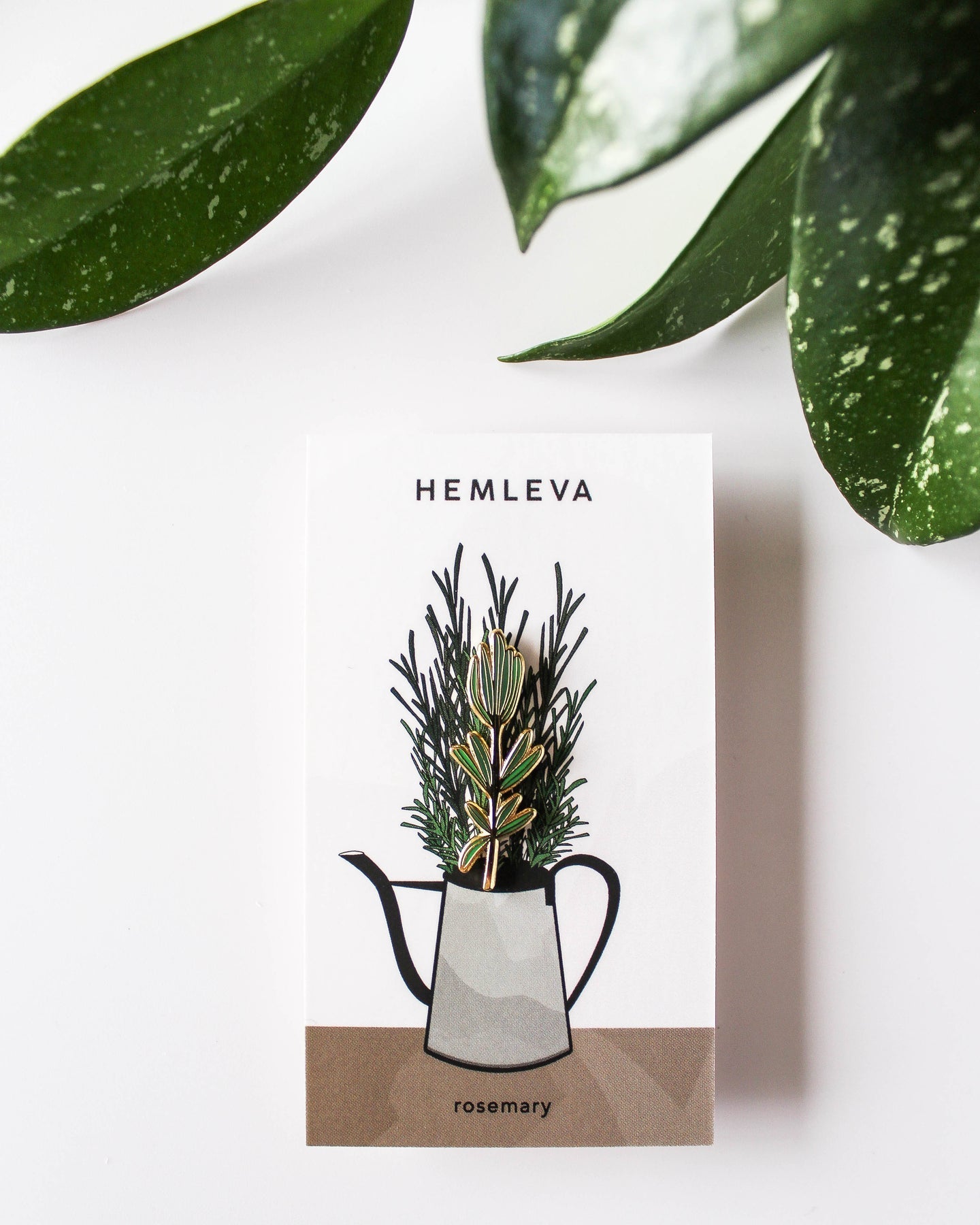 Rosemary enamel pin on gift card with HEMLEVA branding and rosemary illustration