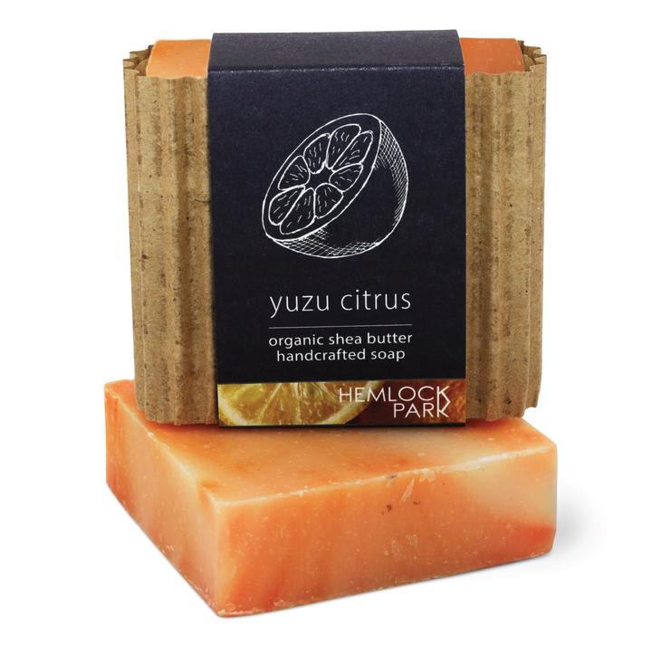 Yuzu citrus organic shea butter soap bar with dark label wrap and kraft paper sides