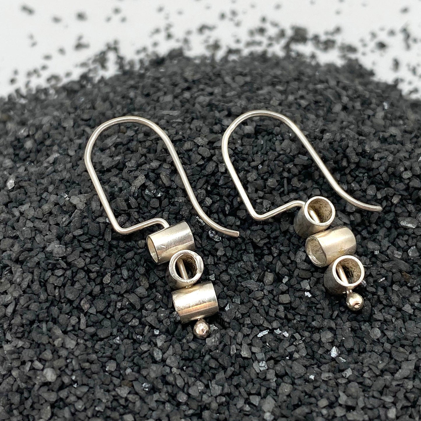 Small sterling pivot hoop earrings with dangling ring and textured drop