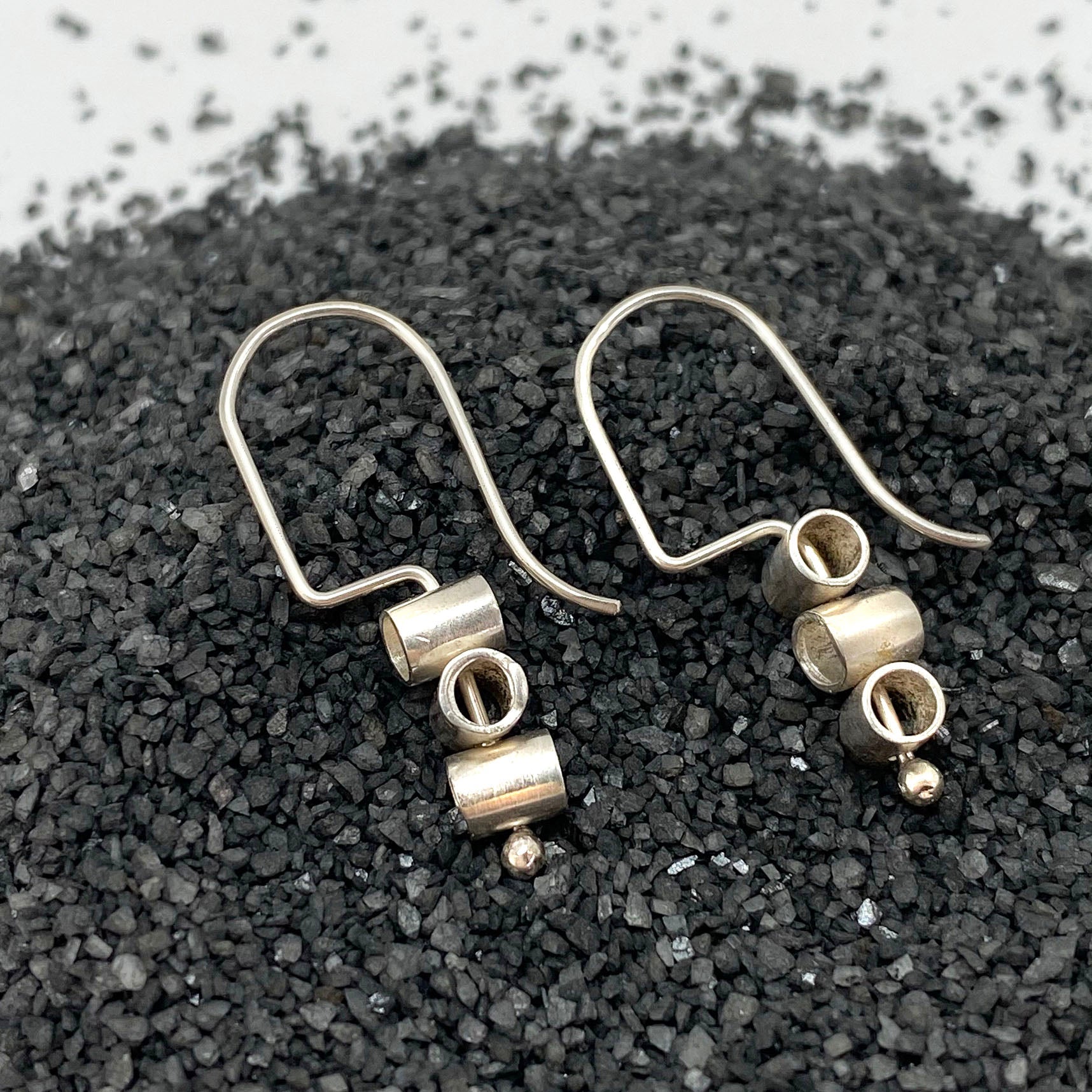 Small sterling pivot hoop earrings with dangling ring and textured drop