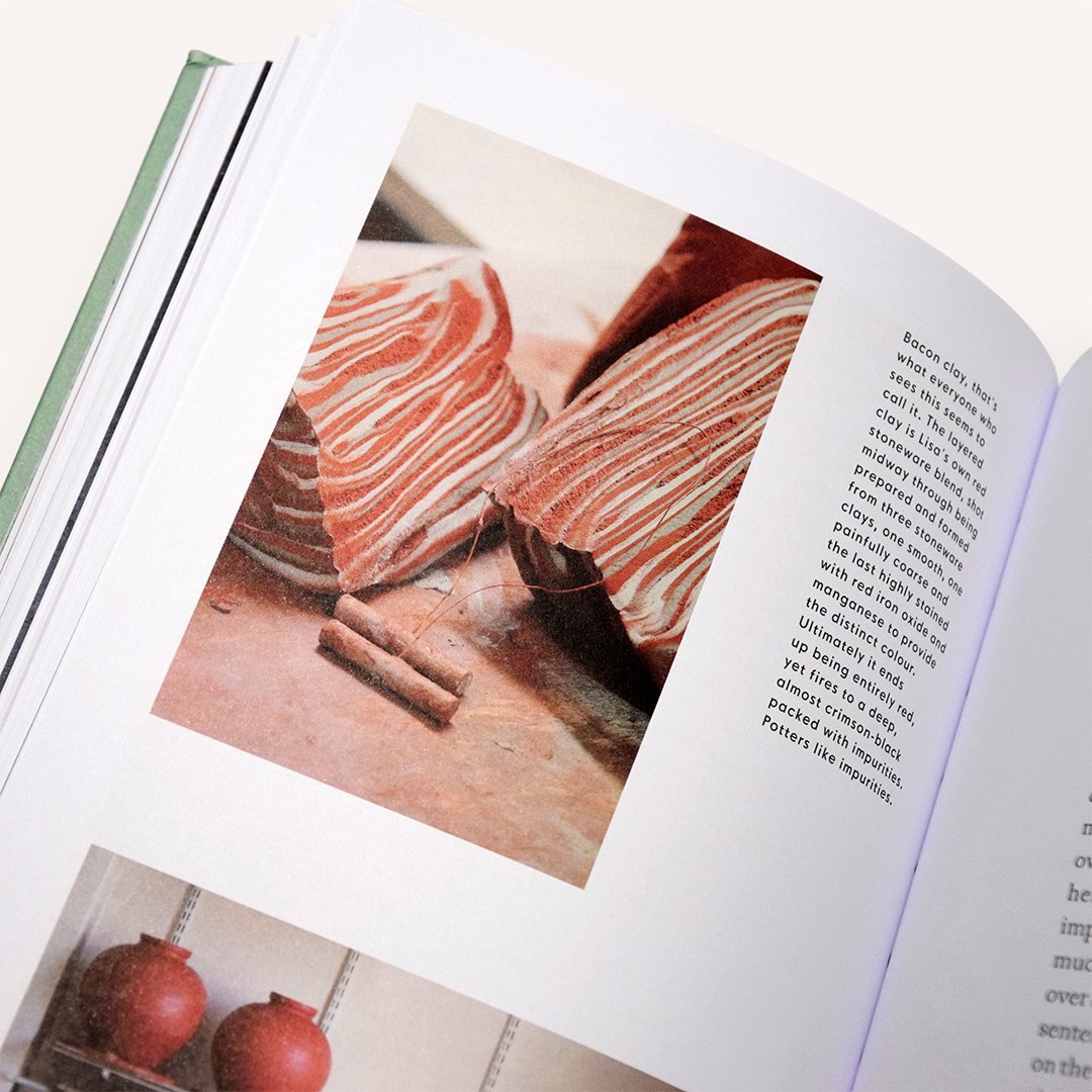 Open pottery book page with photo of hands working on clay