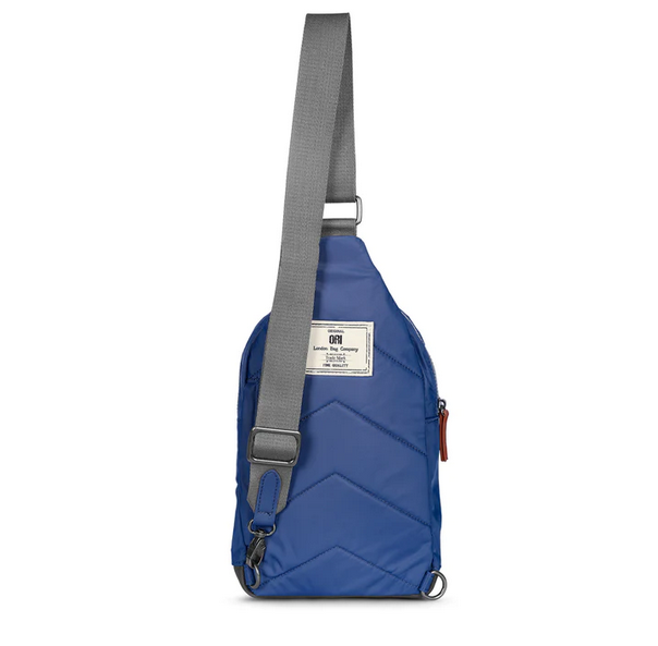 Burnt blue recycled nylon sling bag with front pocket and gray adjustable shoulder strap