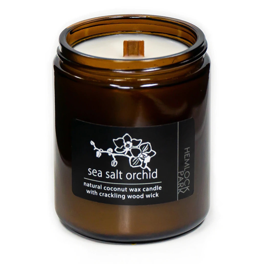 Coconut wax candle in amber jar with wood wick, sea salt orchid scent label