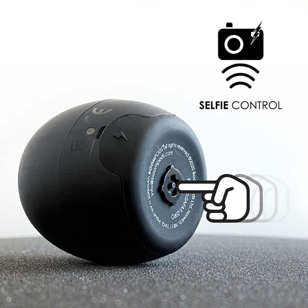 Dark mini wireless speaker with top perforated grille and small lanyard loop