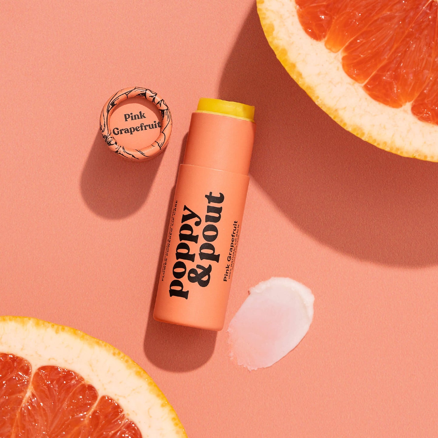 Peach pink grapefruit lip balm tube with yellow cap and white balm swipe
