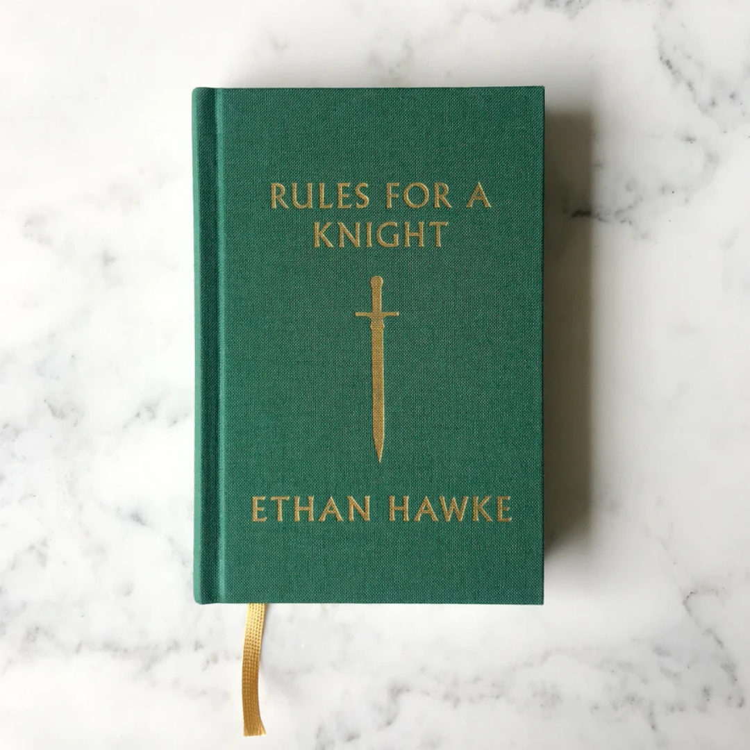 Green hardcover book with gold title text, sword emblem, and fabric bookmark ribbon