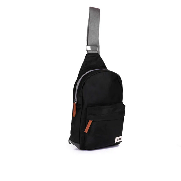 Large black sling bag with adjustable strap, front pocket, and metal zipper pulls