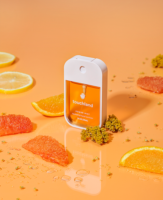 Hydrating hand sanitizer spray bottle with orange label panel and nozzle top
