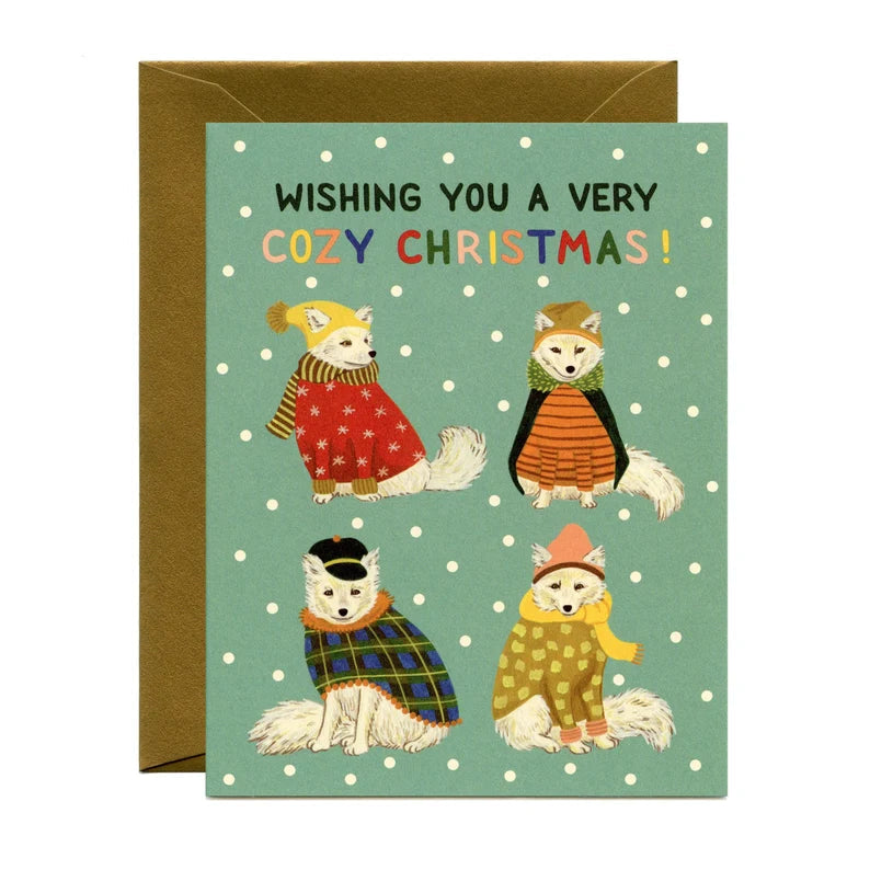 Cozy holiday card with teal front, white polka dots, four illustrated foxes and Christmas message