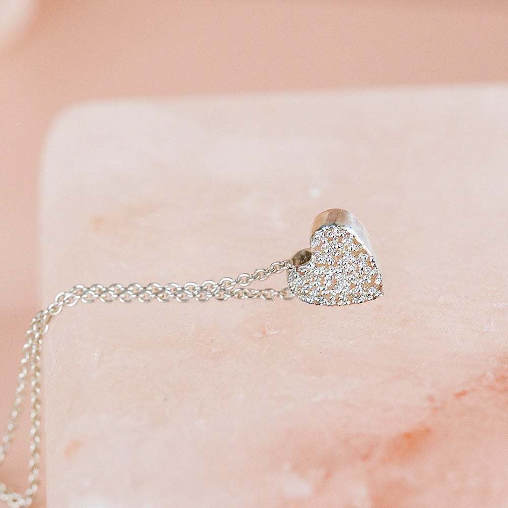 Sterling silver heart necklace with diamond-dusted pendant on chain, side view