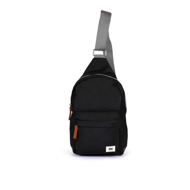 Large black recycled nylon sling bag with adjustable strap and front zip pocket