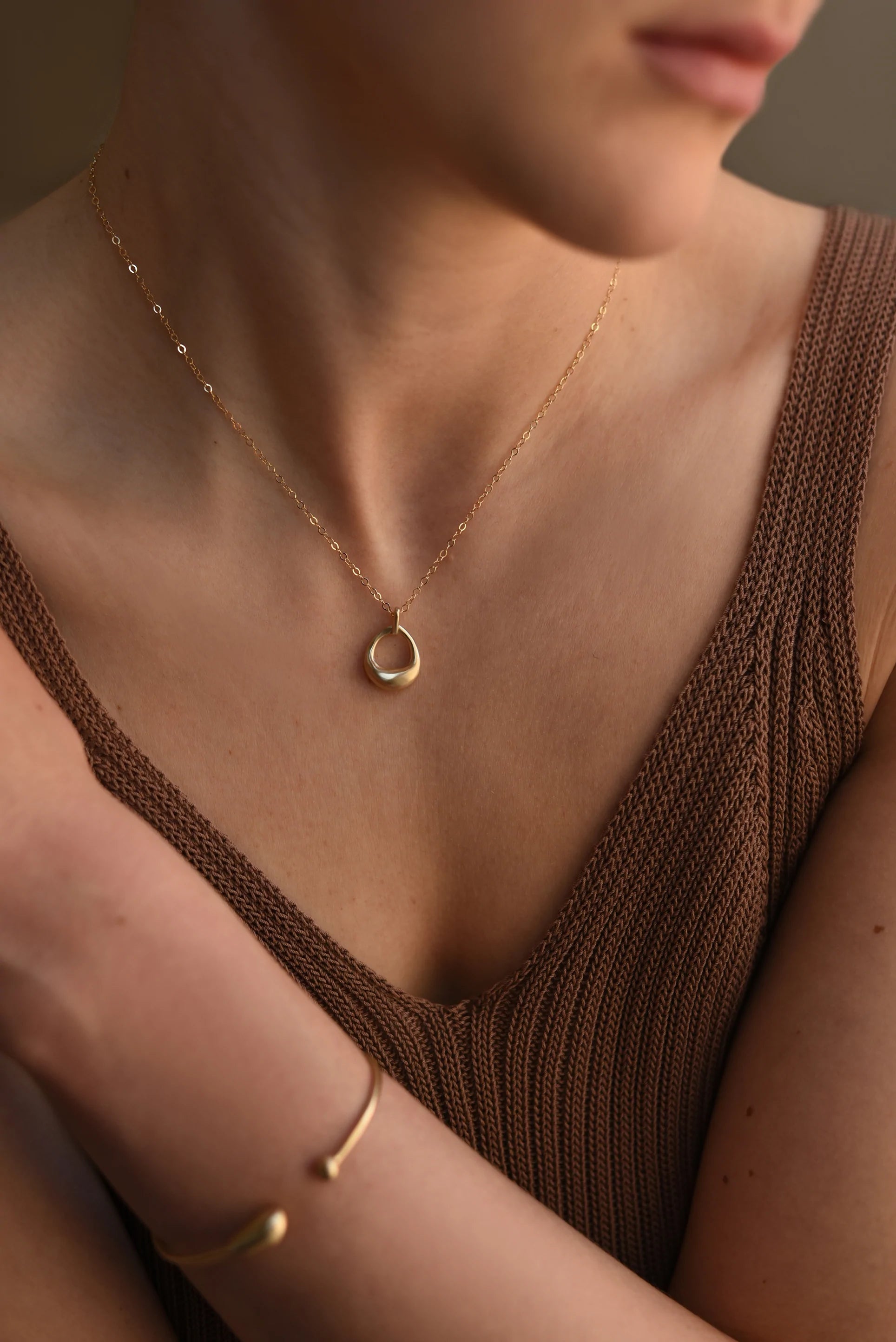 Gold open-circle pendant necklace on thin chain, worn