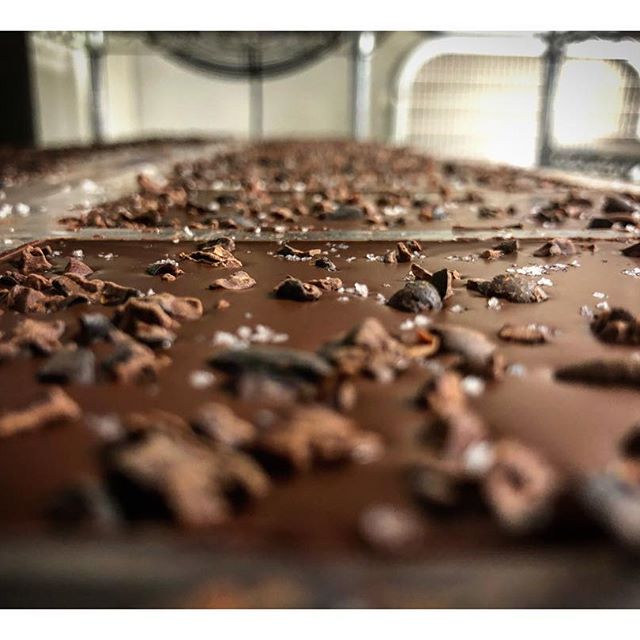 Dark chocolate surface with nibs and sea salt flecks, close-up