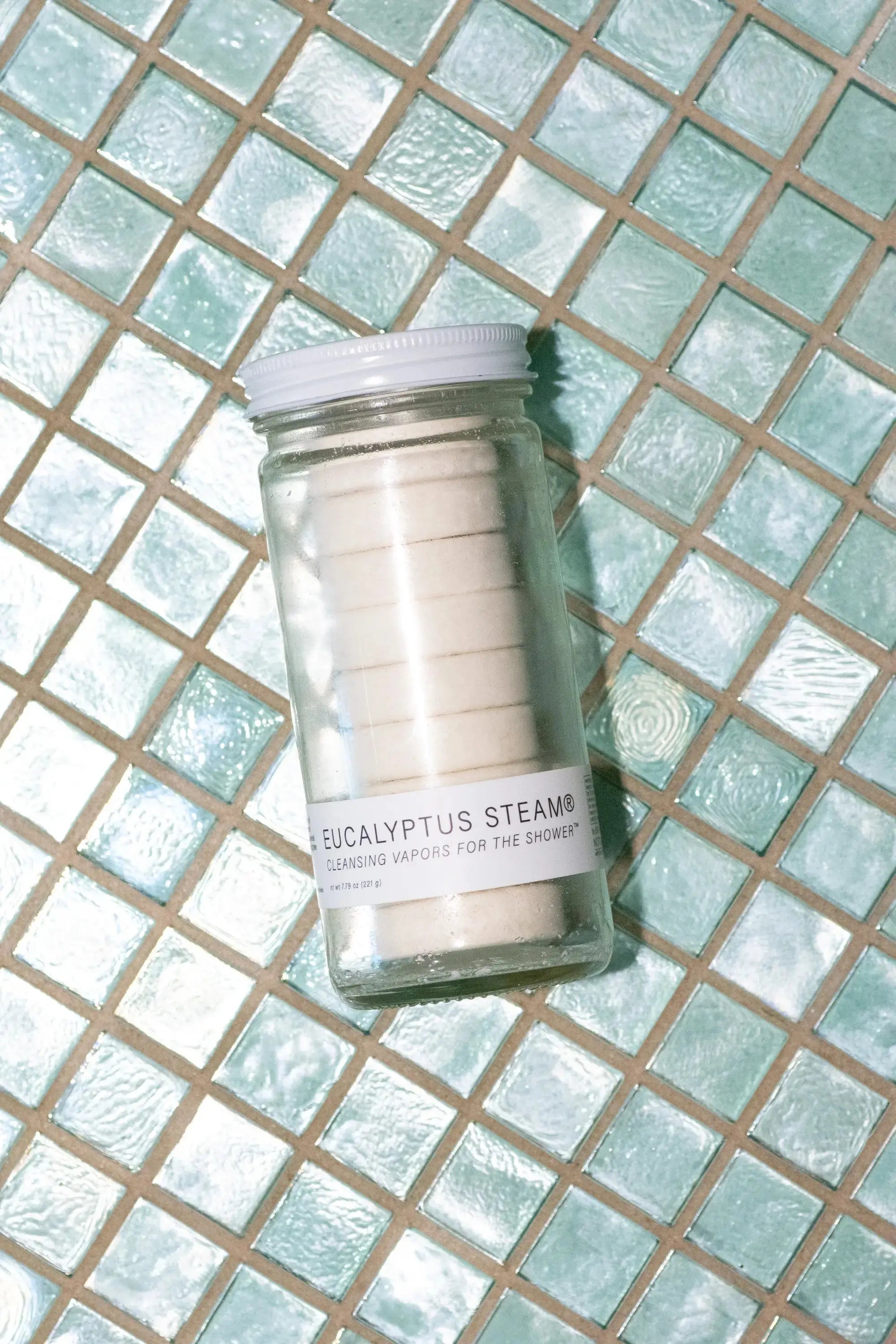 Eucalyptus Steam scented wax jar on tiled surface, clear glass with white lid