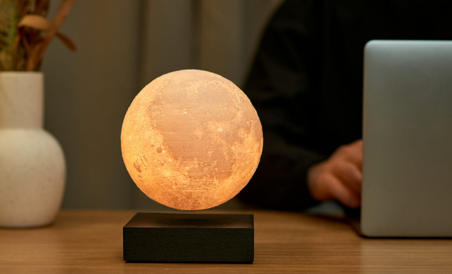 Moon lamp with warm glowing frosted sphere on black base