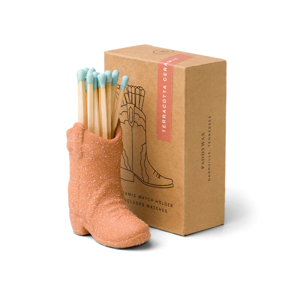 Ceramic cowboy boot match holder in terracotta, holding blue-tipped wooden matches