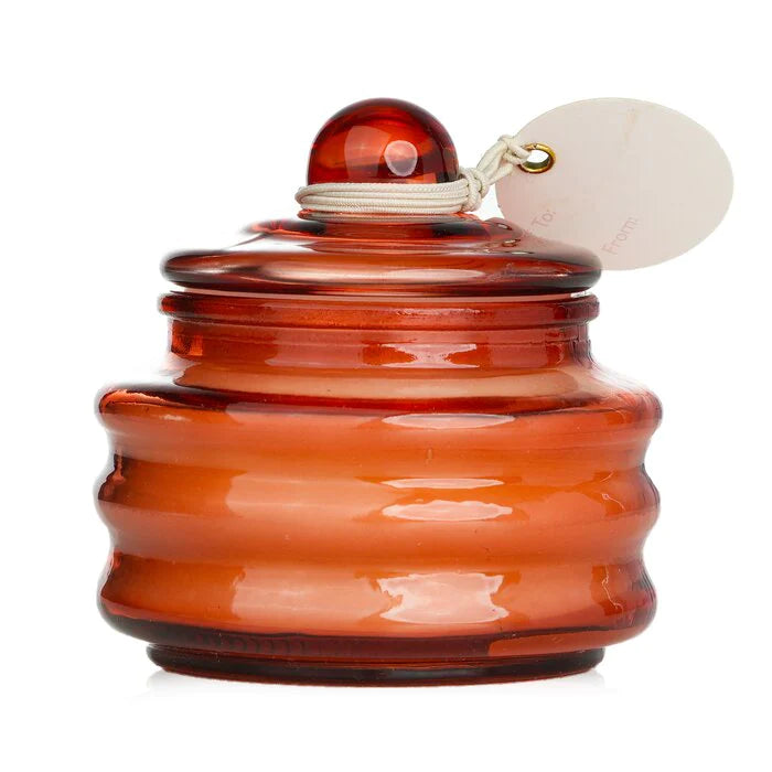 Orange glass jar candle with glass dome lid and round scent tag