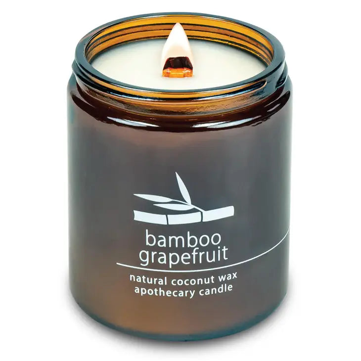 Coconut wax candle in amber jar with wood wick, bamboo grapefruit scent label