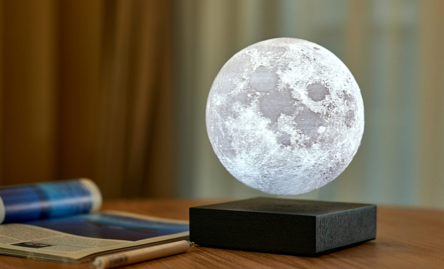 Moon lamp with cool glowing frosted sphere on black base