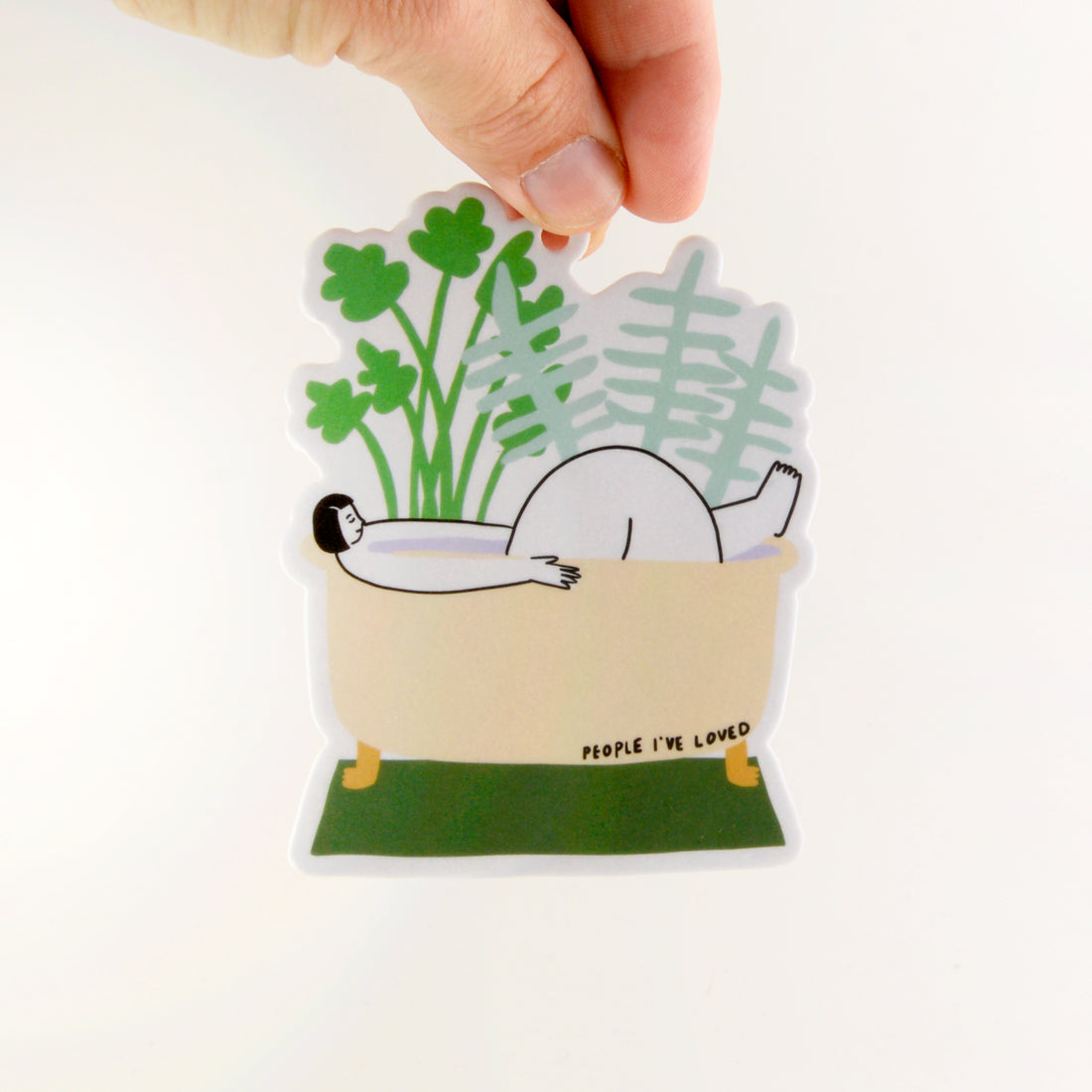 Lavender air freshener shaped as a cartoon plant in a pot, held by a hand