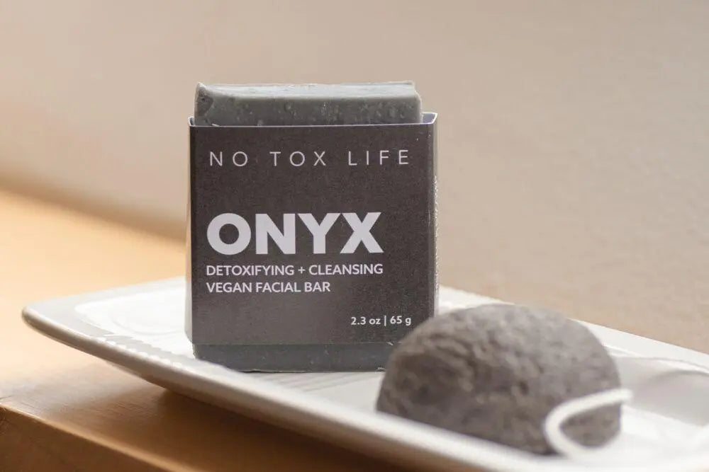 Vegan detoxifying facial cleansing bar with ONYX branding on a charcoal box